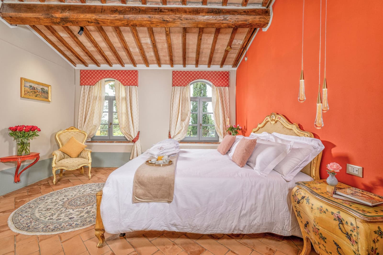 Villa Poggio d'Oro — a terracotta-walled bedroom with antique furniture