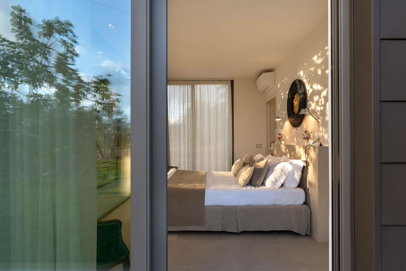 Casa Lilia — a bedroom seen through its glass wall