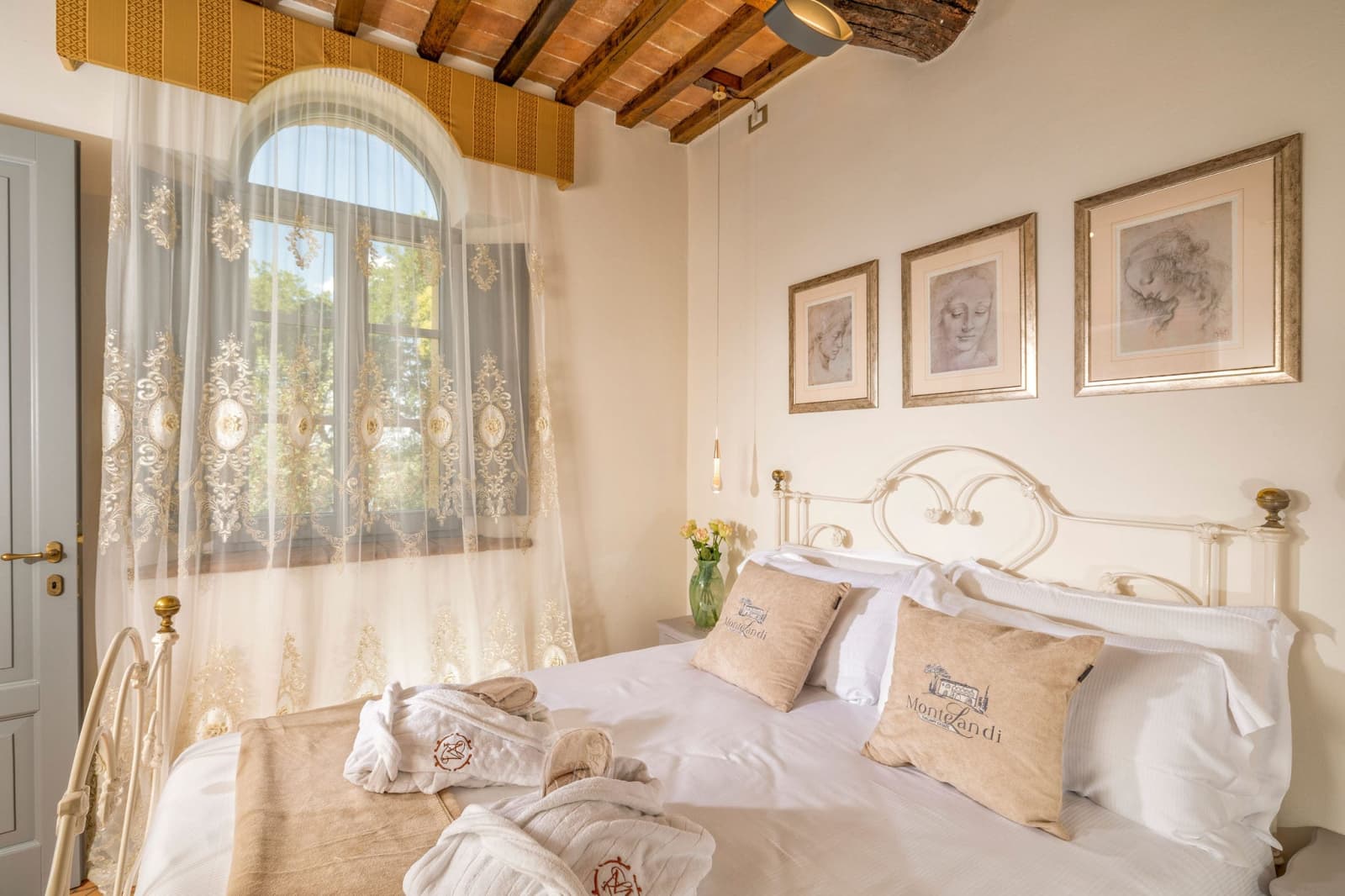 Villa Poggio d'Oro — a bright bedroom beneath an arched window