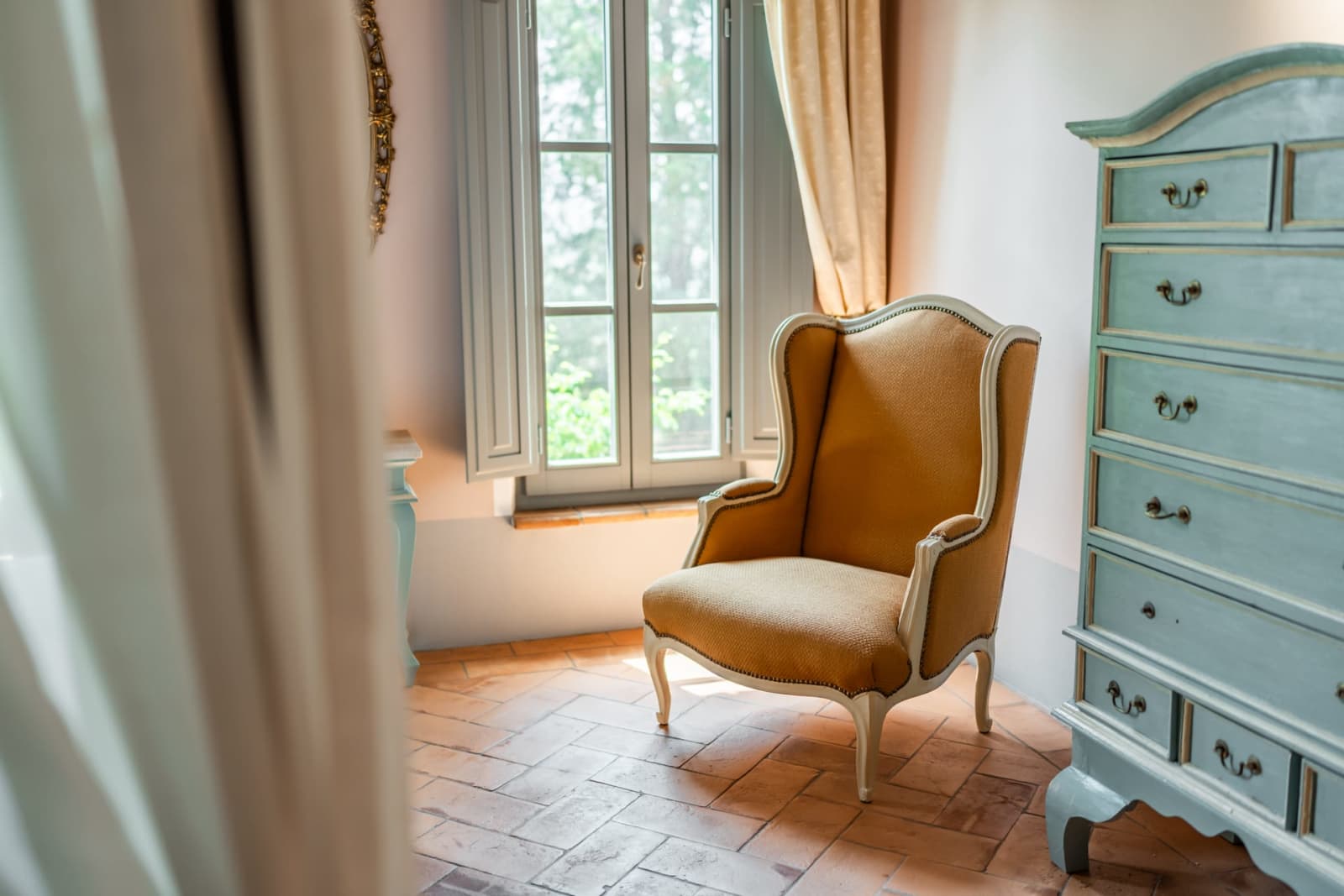 Villa Poggio d'Oro — a reading corner beside a painted dresser