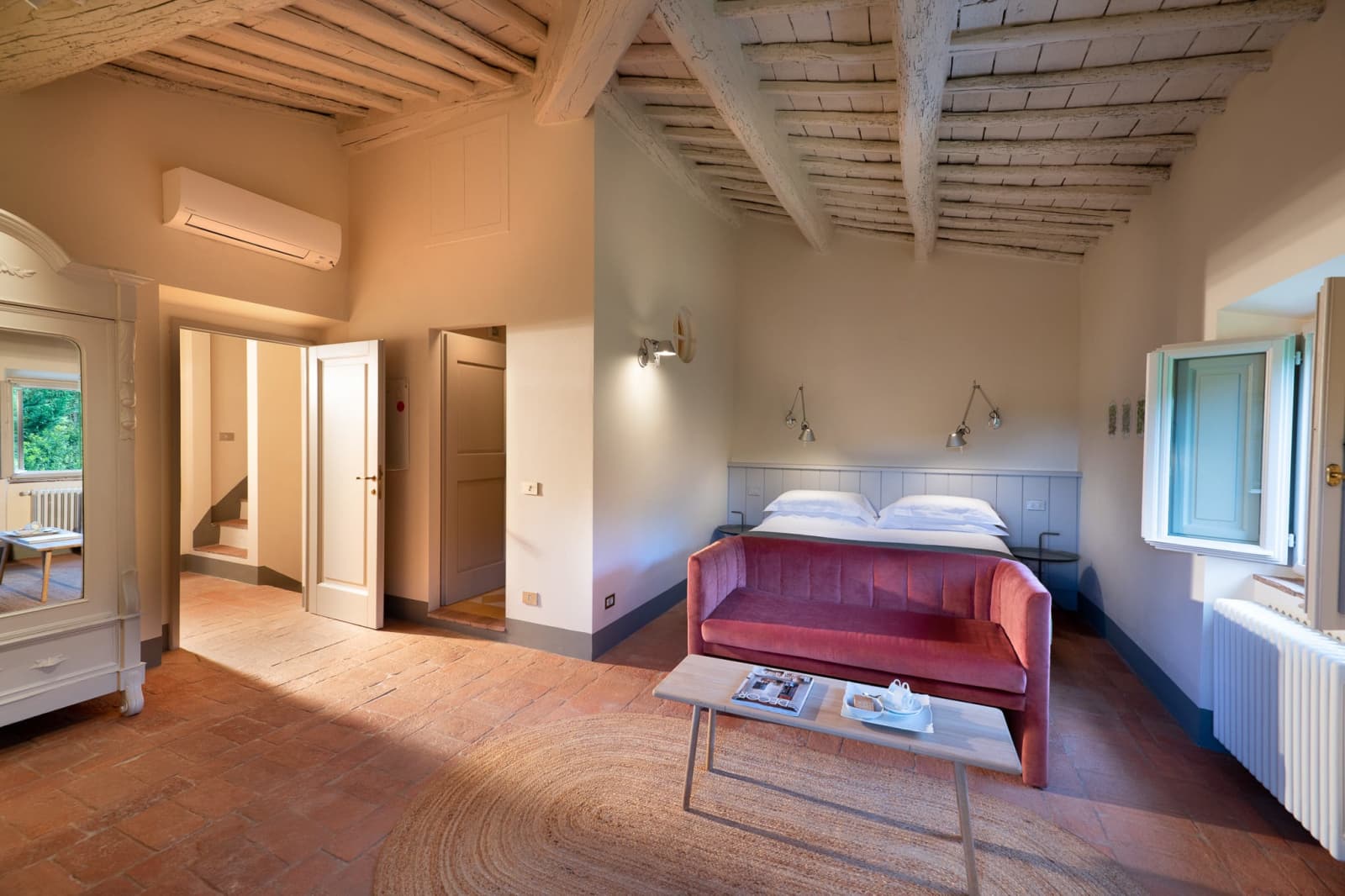 Villa Erbavoglio — a bedroom with sofa and beamed ceiling