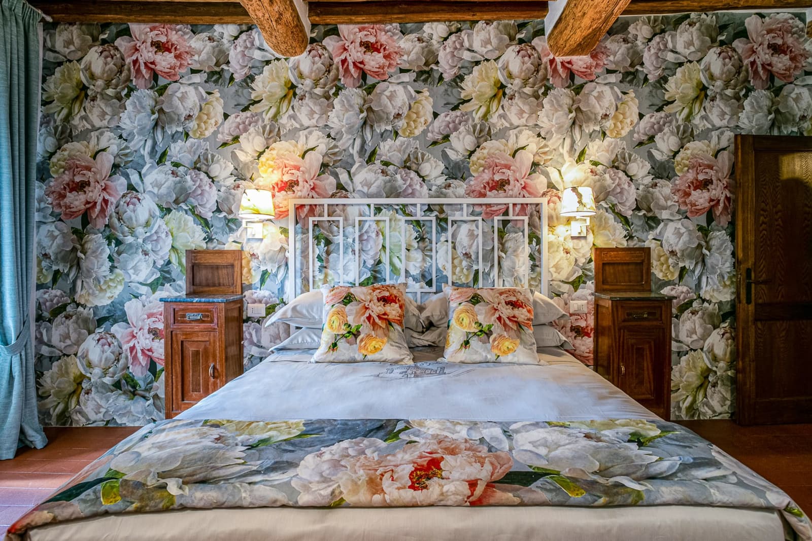 Casa dell'Erta — a wrought-iron bed against floral wallpaper