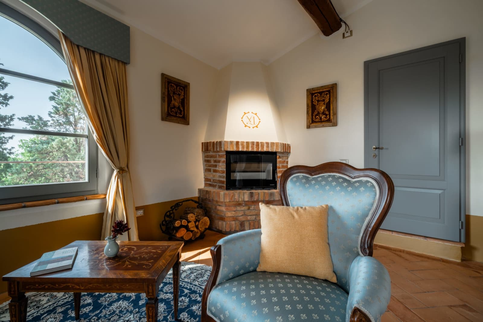 Villa Poggio d'Oro — a fireplace corner with a blue armchair