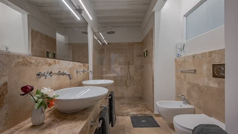 Borgo delle Vigne — a bathroom with double vessel sinks and a walk-in shower