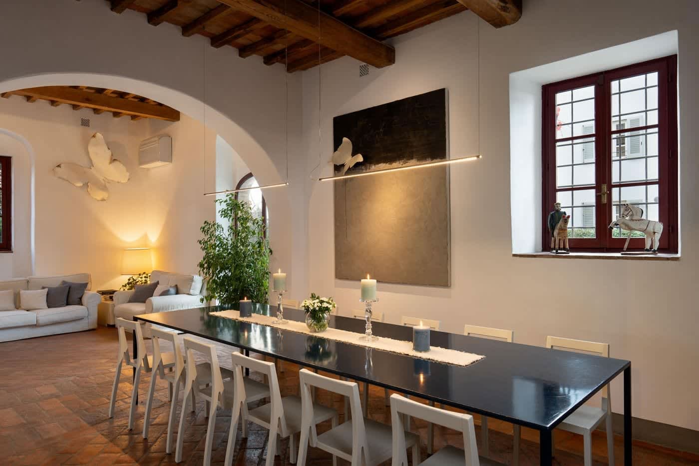 Villa Castellaro — the dining table in the living hall beneath beamed ceilings