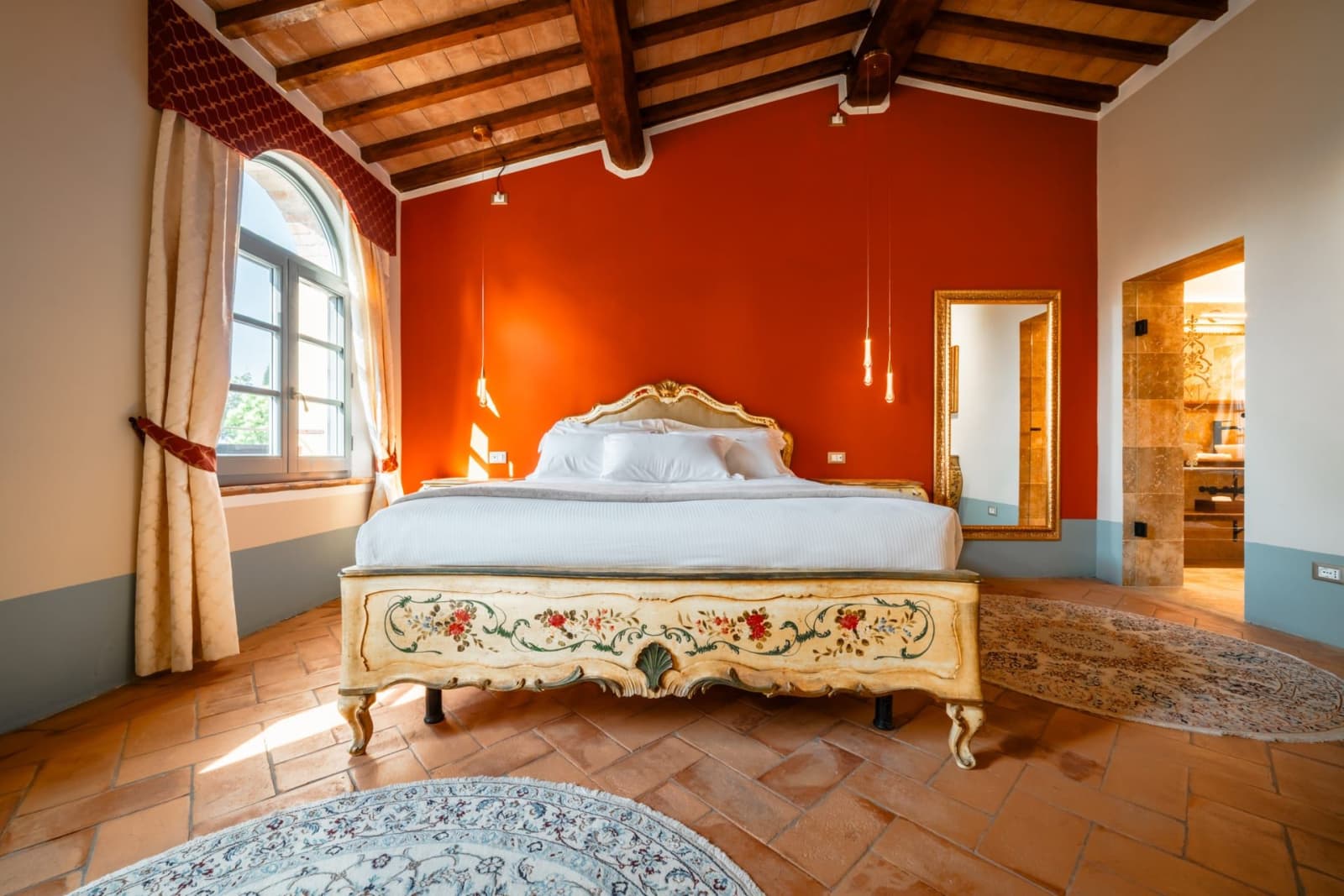 Villa Poggio d'Oro — a terracotta-walled bedroom with a gilded bed