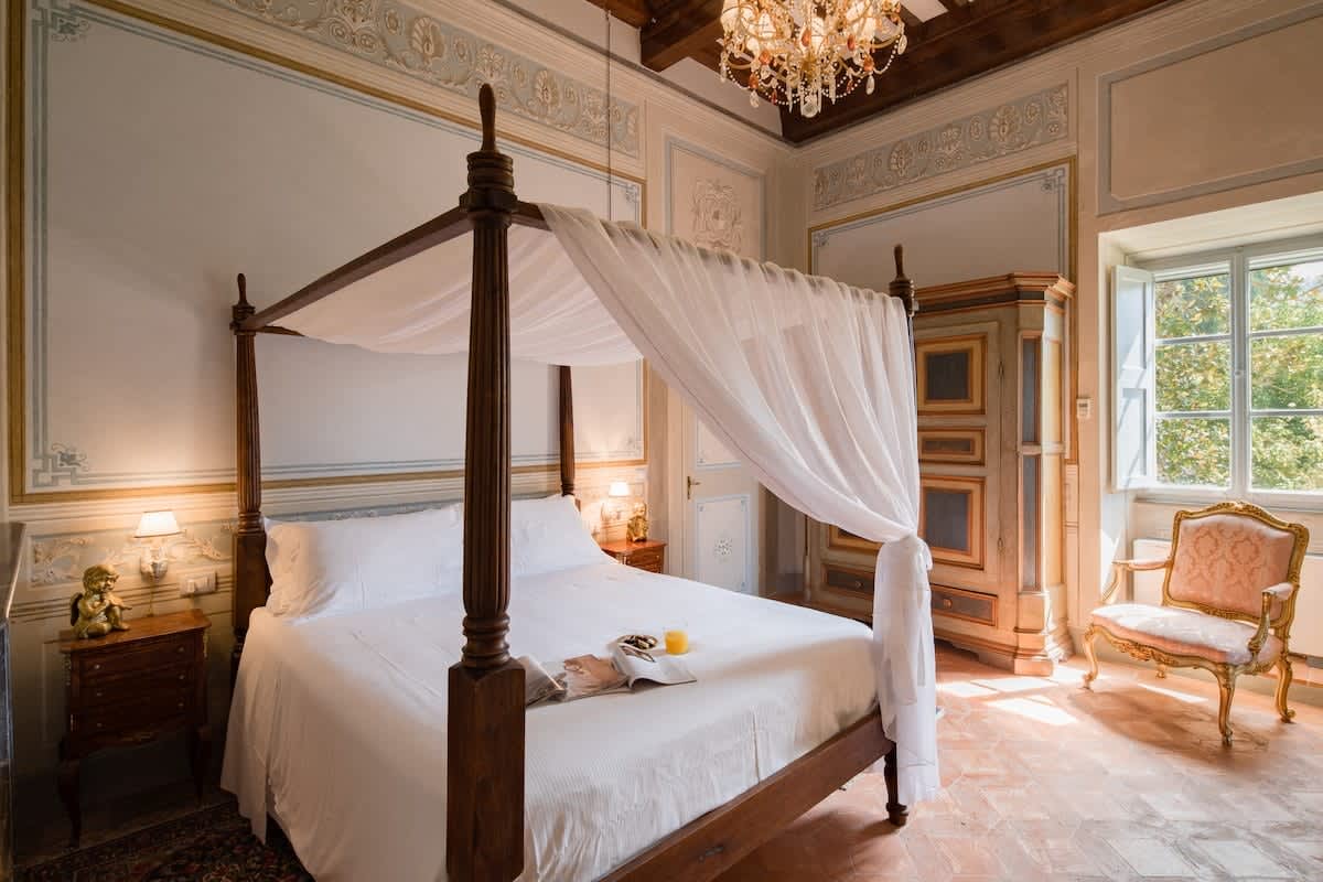 Villa della Cappella — a canopy bed dressed in white