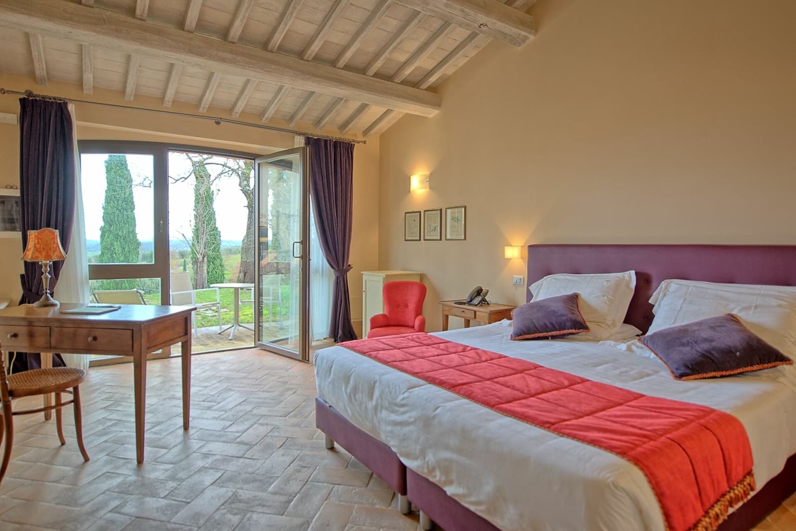 Tenuta La Barricaia — a double bedroom with a red throw beneath the beams