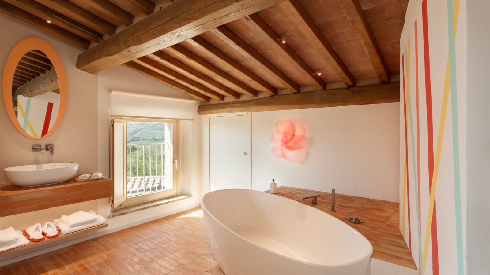 Podere Mastrojanni — a bathroom with a rainbow-striped wall and freestanding tub