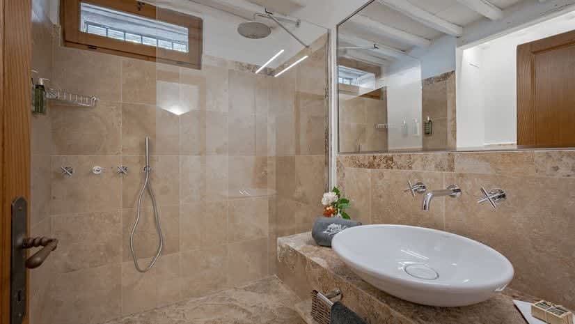 Borgo delle Vigne — a bathroom with a beamed ceiling and garden-facing window