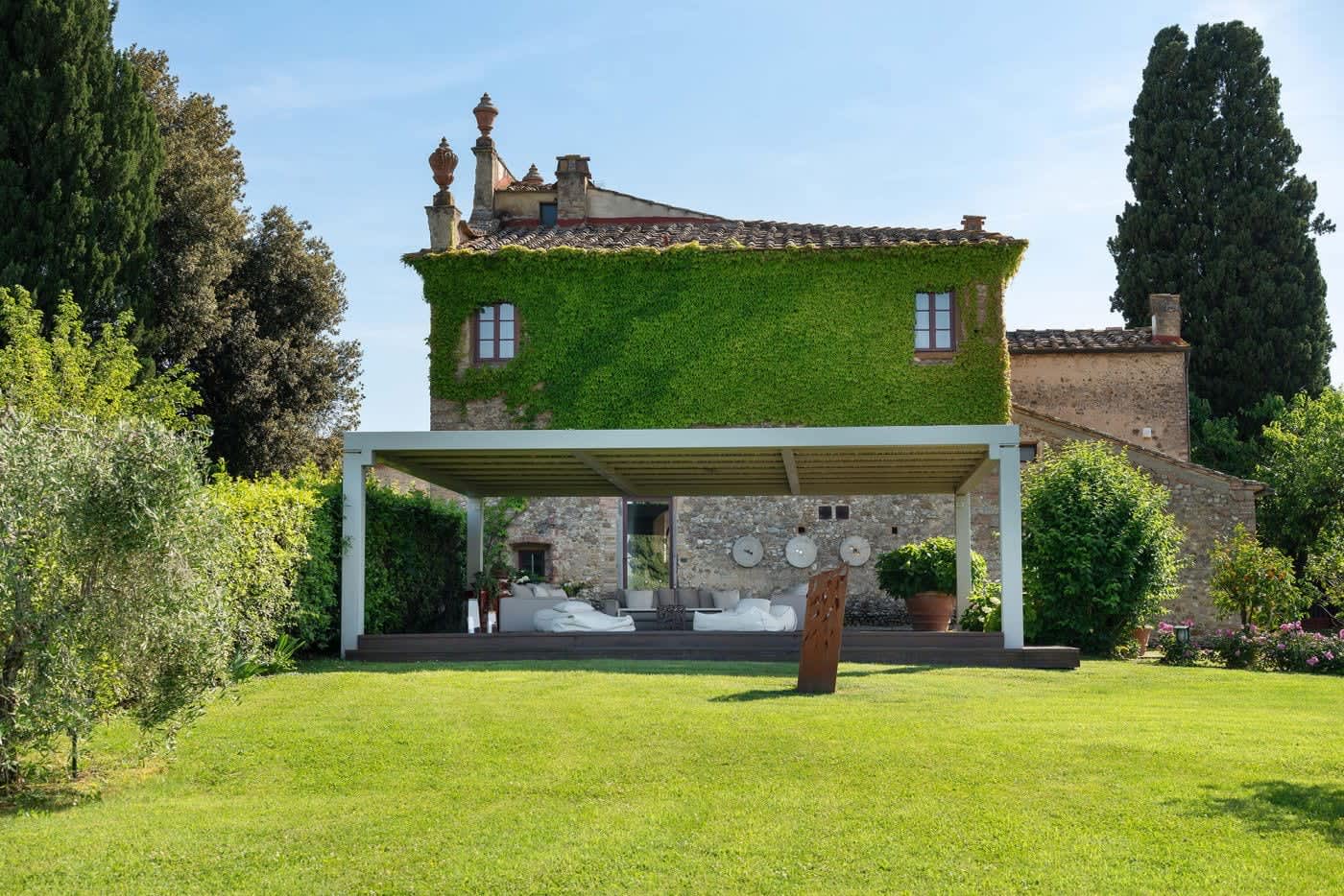 Villa Castellaro — the ivy-covered villa behind its lawn and pergola