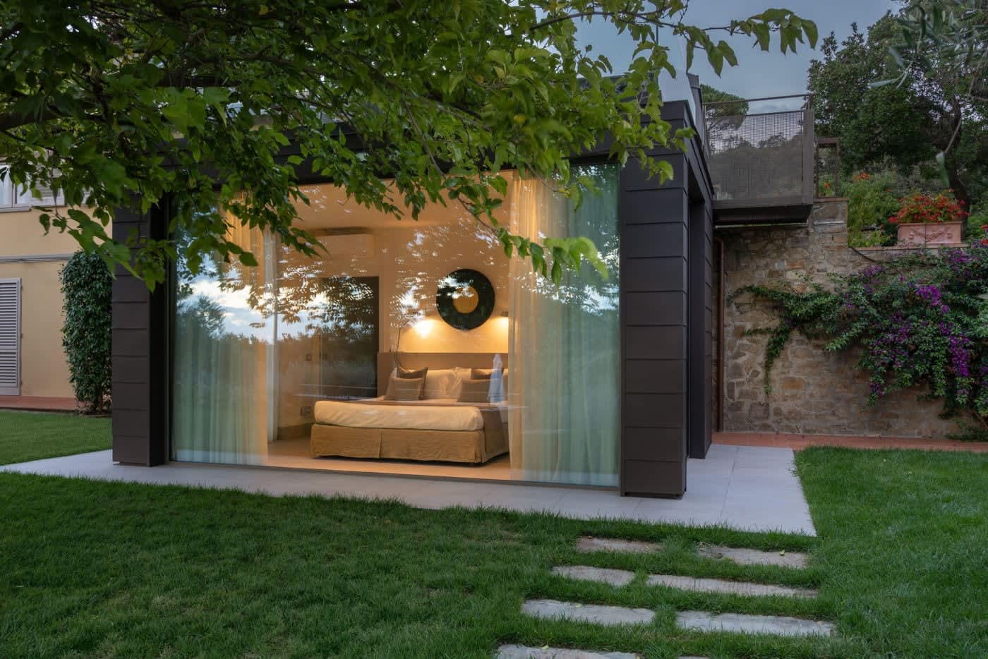 Casa Lilia — the glass-walled bedroom wing lit at dusk