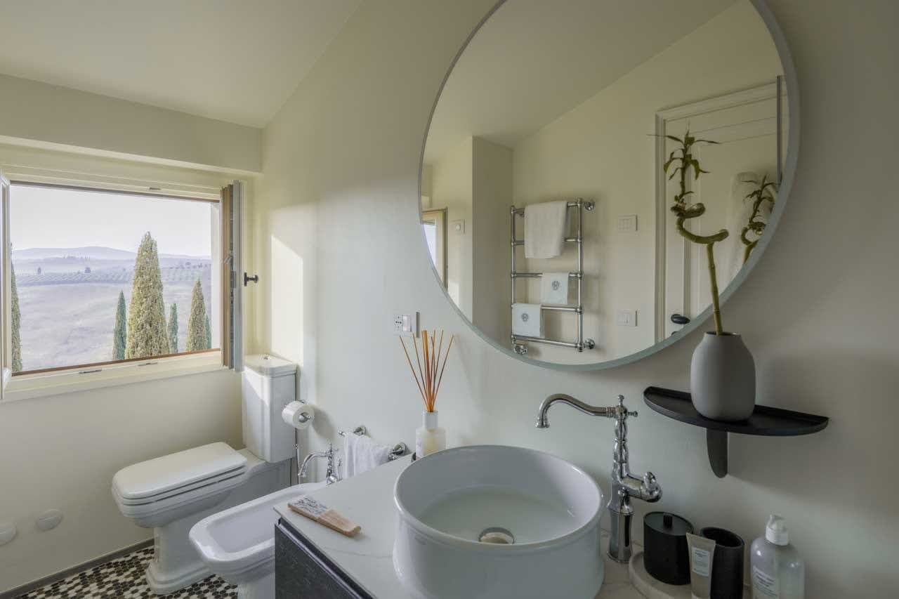 Tenuta Belvedere Estate: Tenuta Belvedere — a villa bathroom with a round mirror
