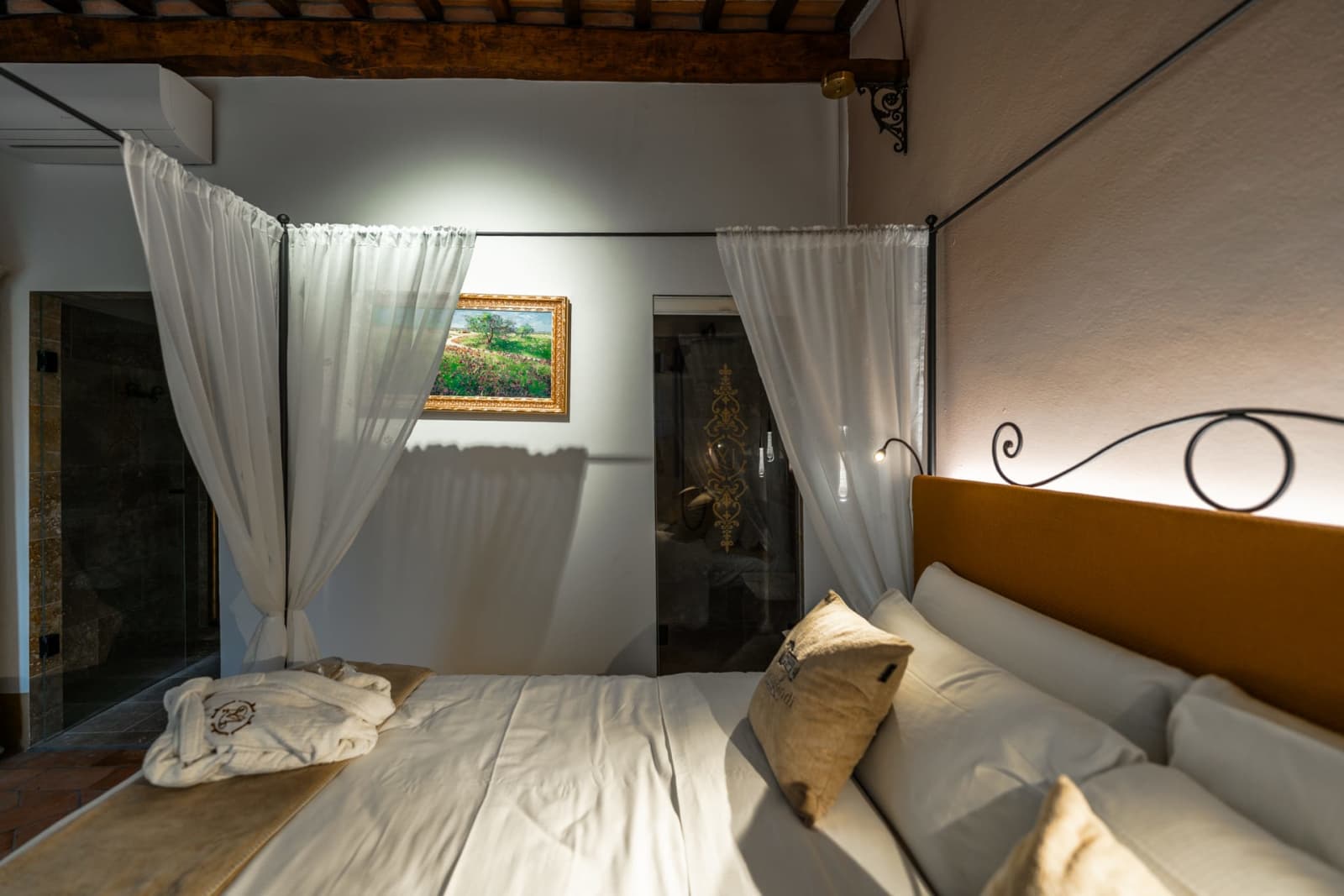 Villa Poggio d'Oro — a canopied bed against a dark accent wall
