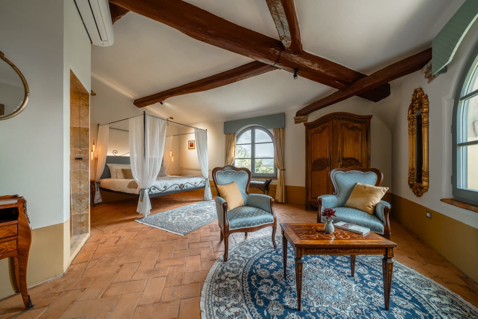 Villa Poggio d'Oro — a suite with a sitting area and canopy bed