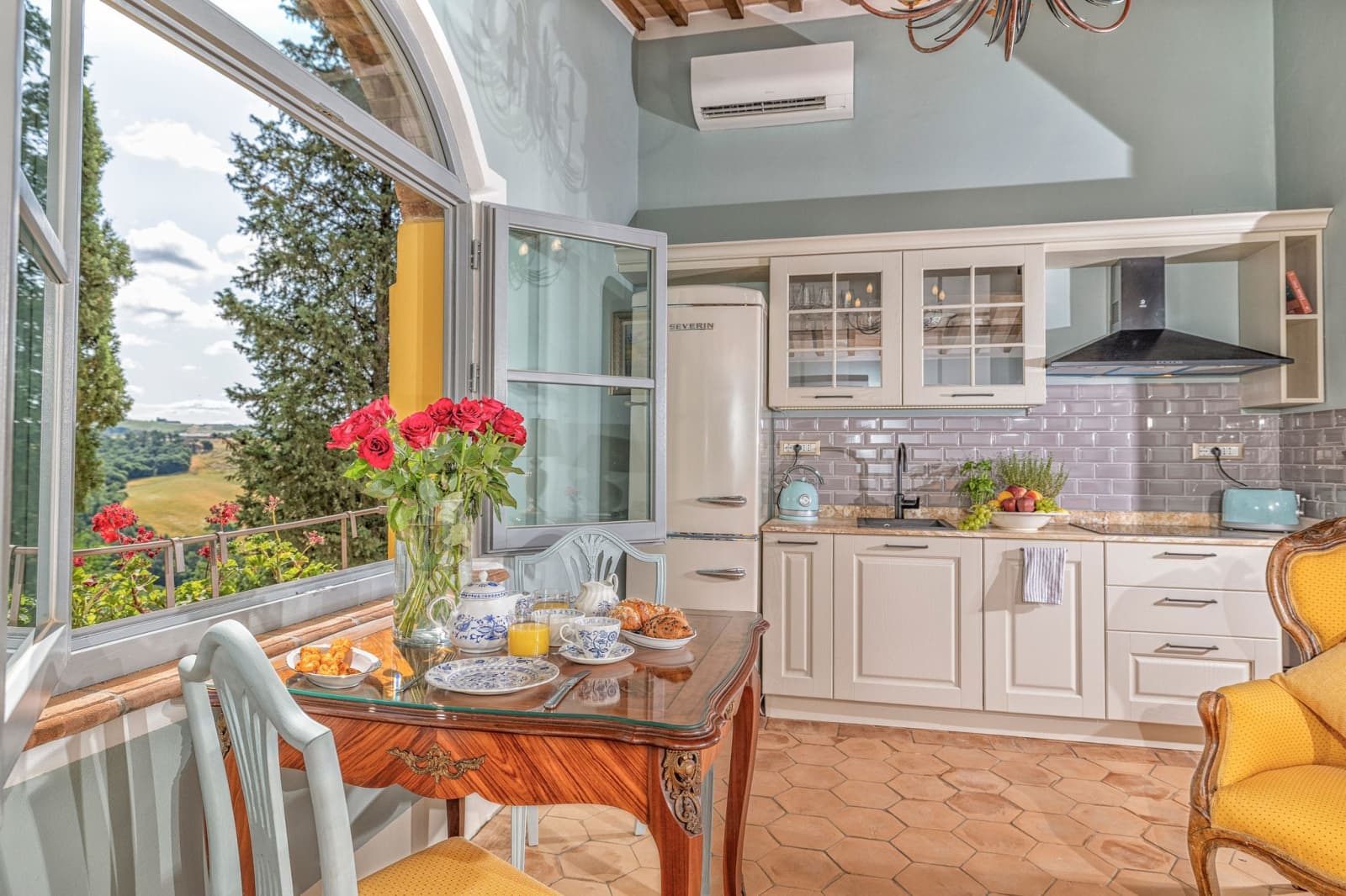Villa Poggio d'Oro — a kitchen table by a window, set with roses