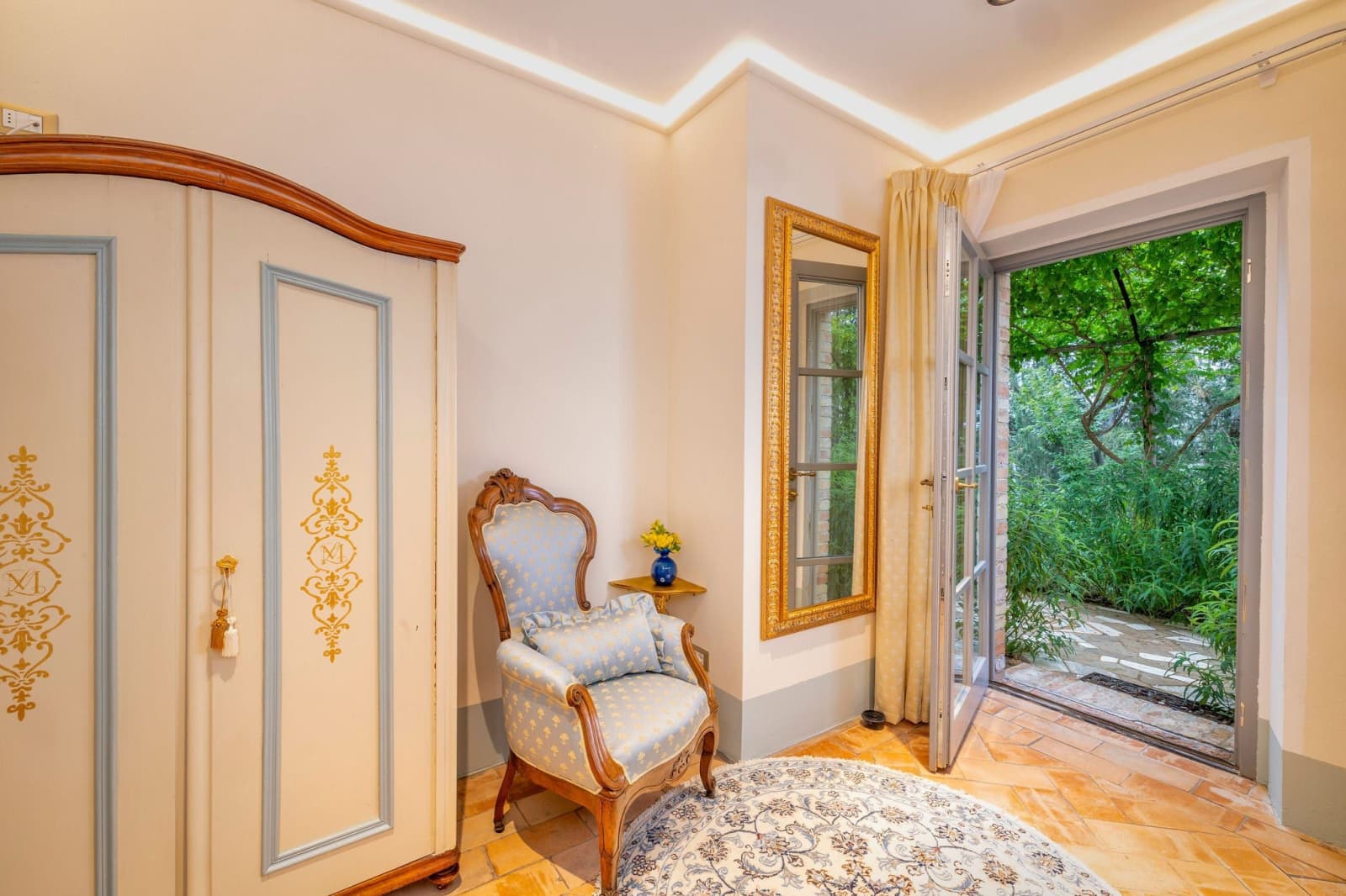 Villa Poggio d'Oro — a bedroom corner with an armchair by the garden door