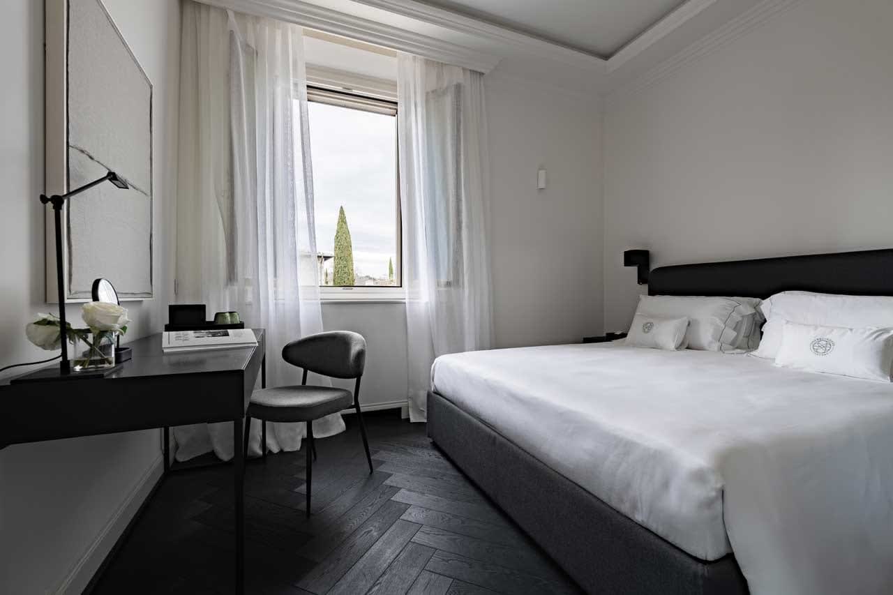 Tenuta Belvedere Estate: Tenuta Belvedere — a villa bedroom in dark, tailored tones