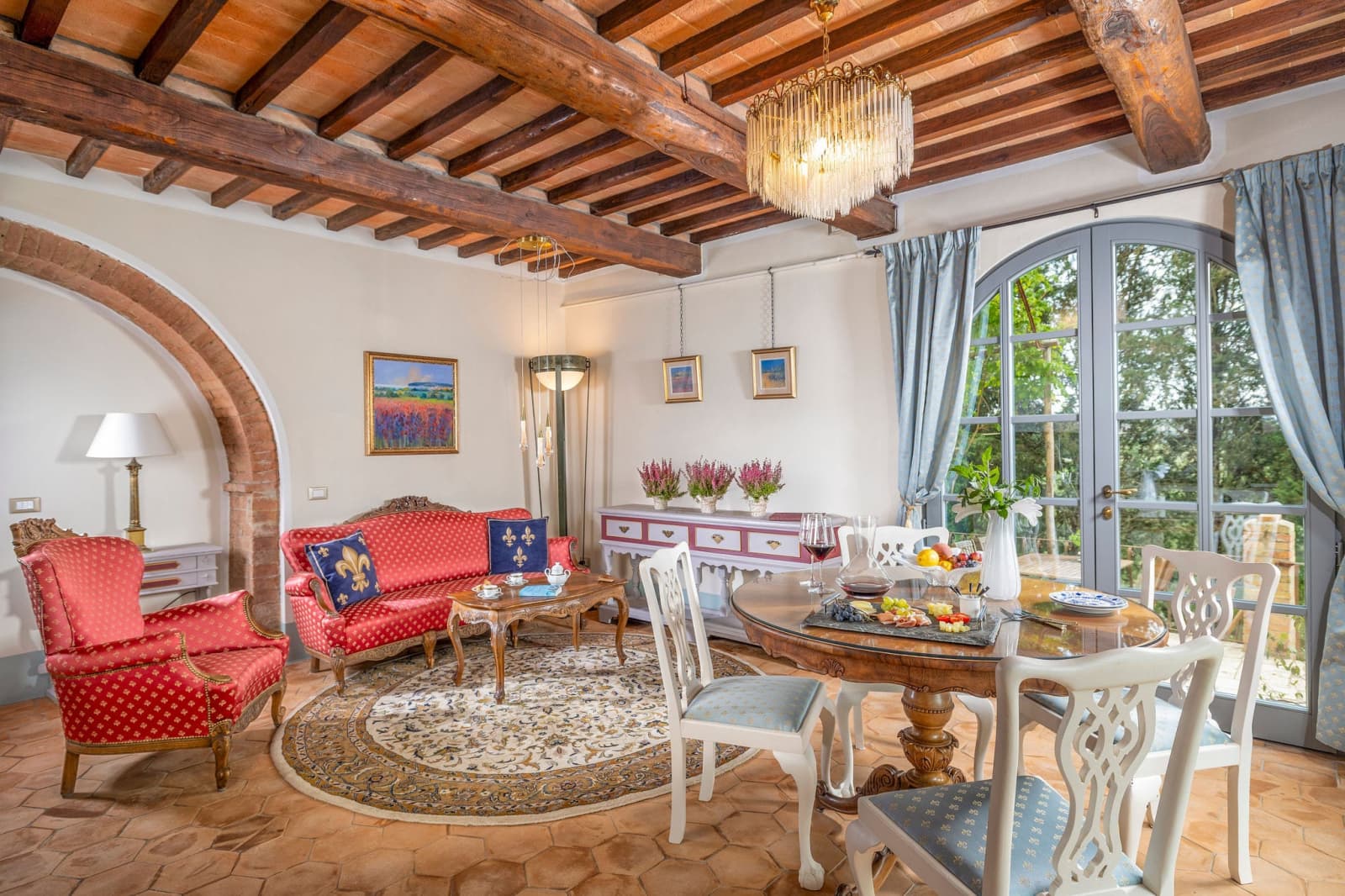 Villa Poggio d'Oro — a sitting and dining room beneath a chandelier