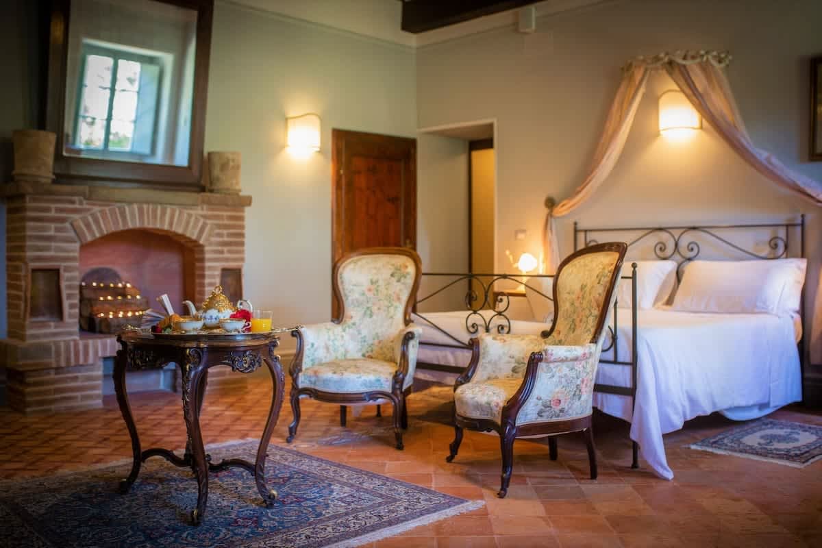 Villa della Cappella — a bedroom seating corner with antique armchairs