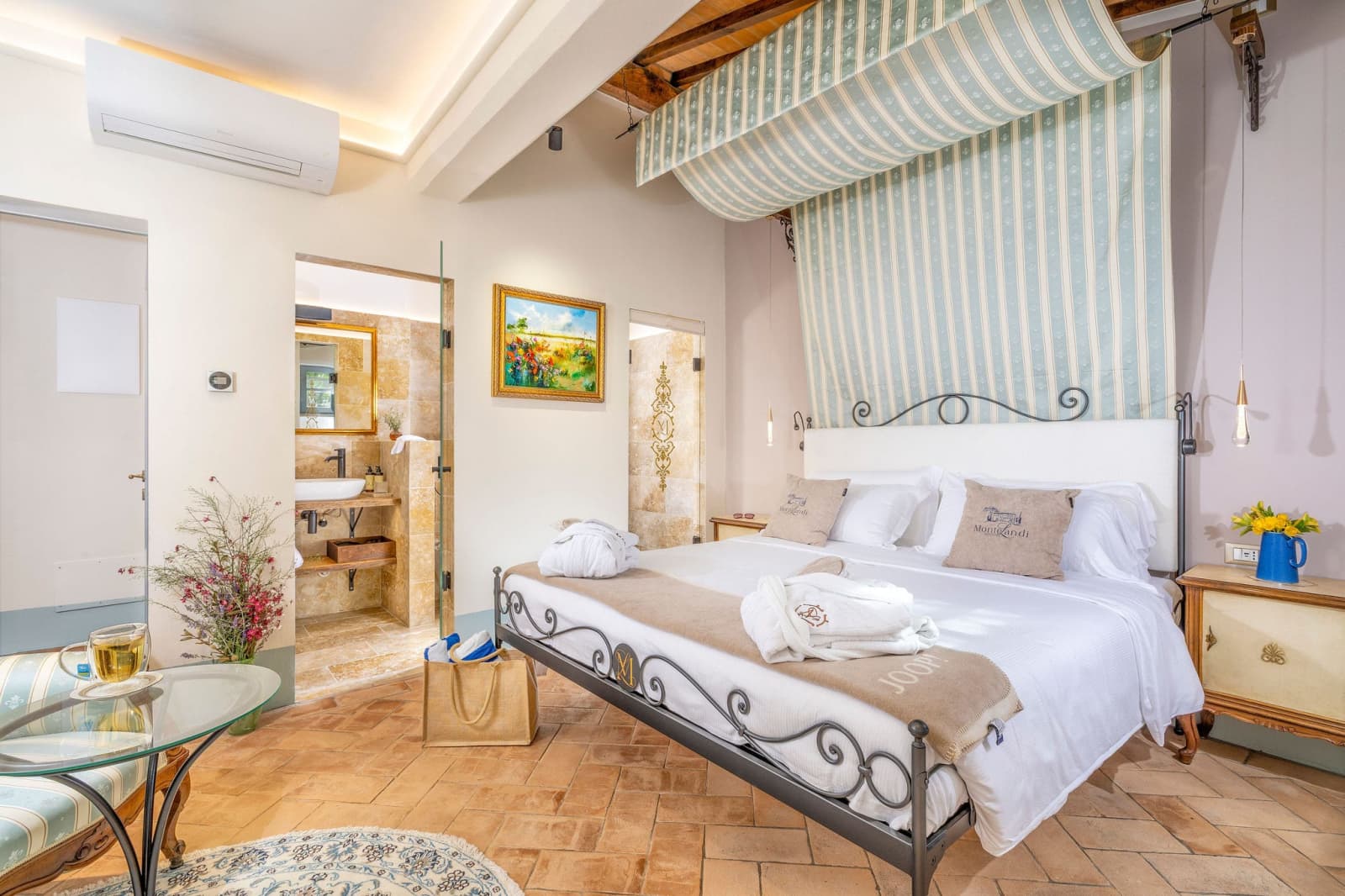 Villa Poggio d'Oro — a bedroom with a striped canopy