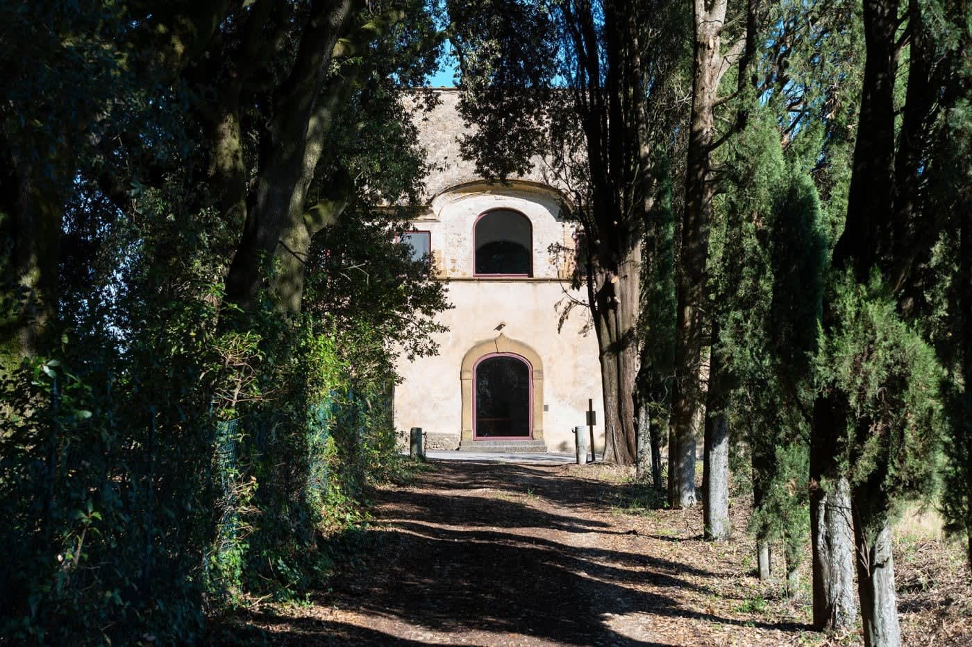 Villa Castellaro — a shaded stone façade among tall trees