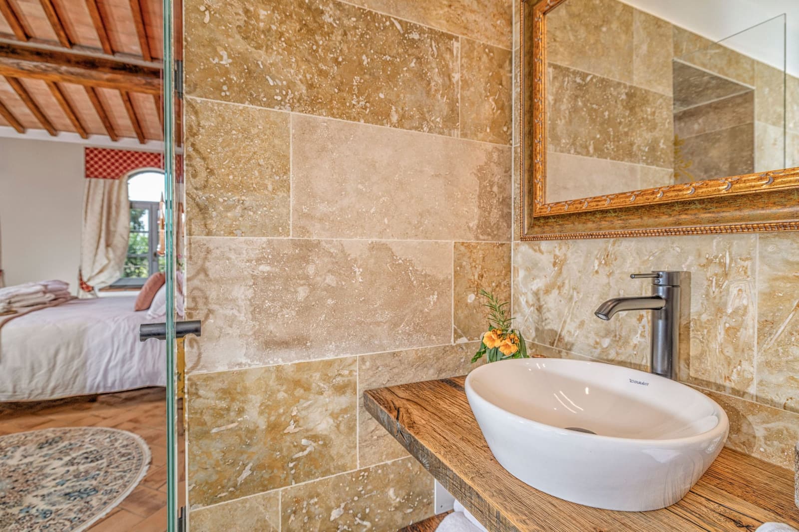 Villa Poggio d'Oro — a travertine bathroom with a vessel basin