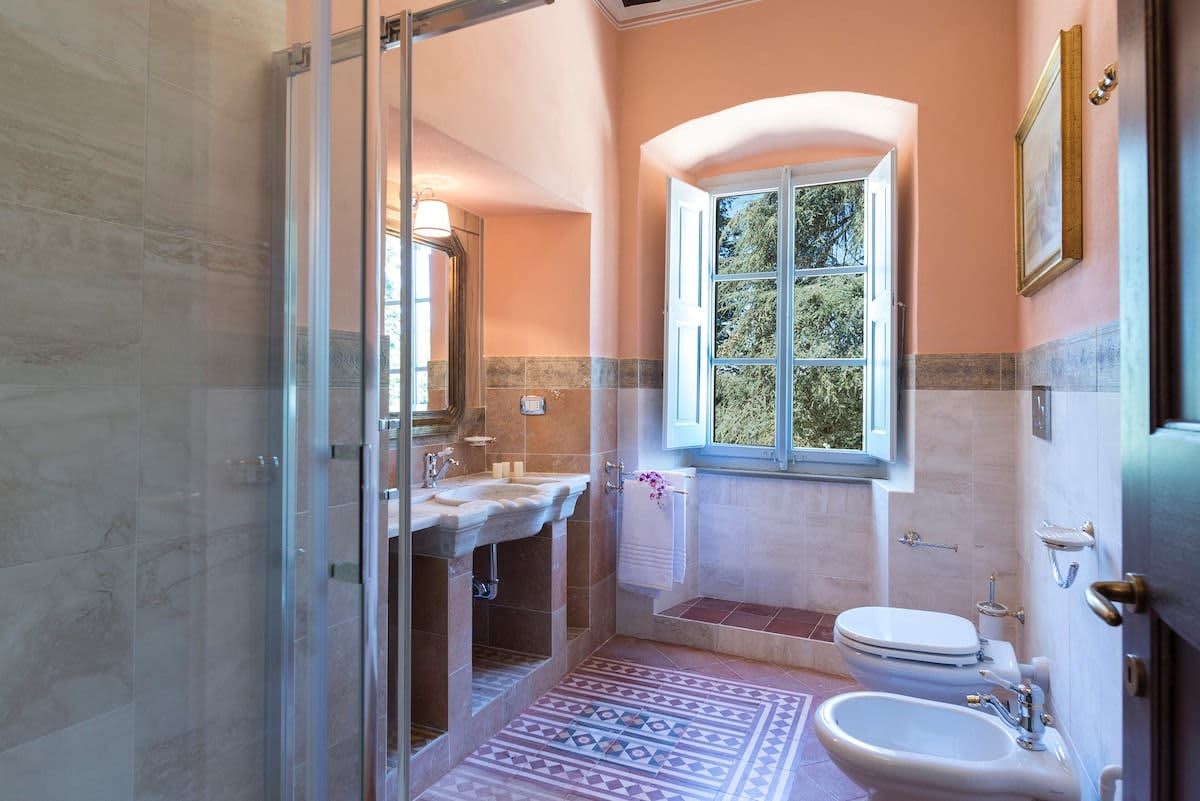 Villa della Cappella — an en-suite bathroom with warm terracotta mosaic tiling