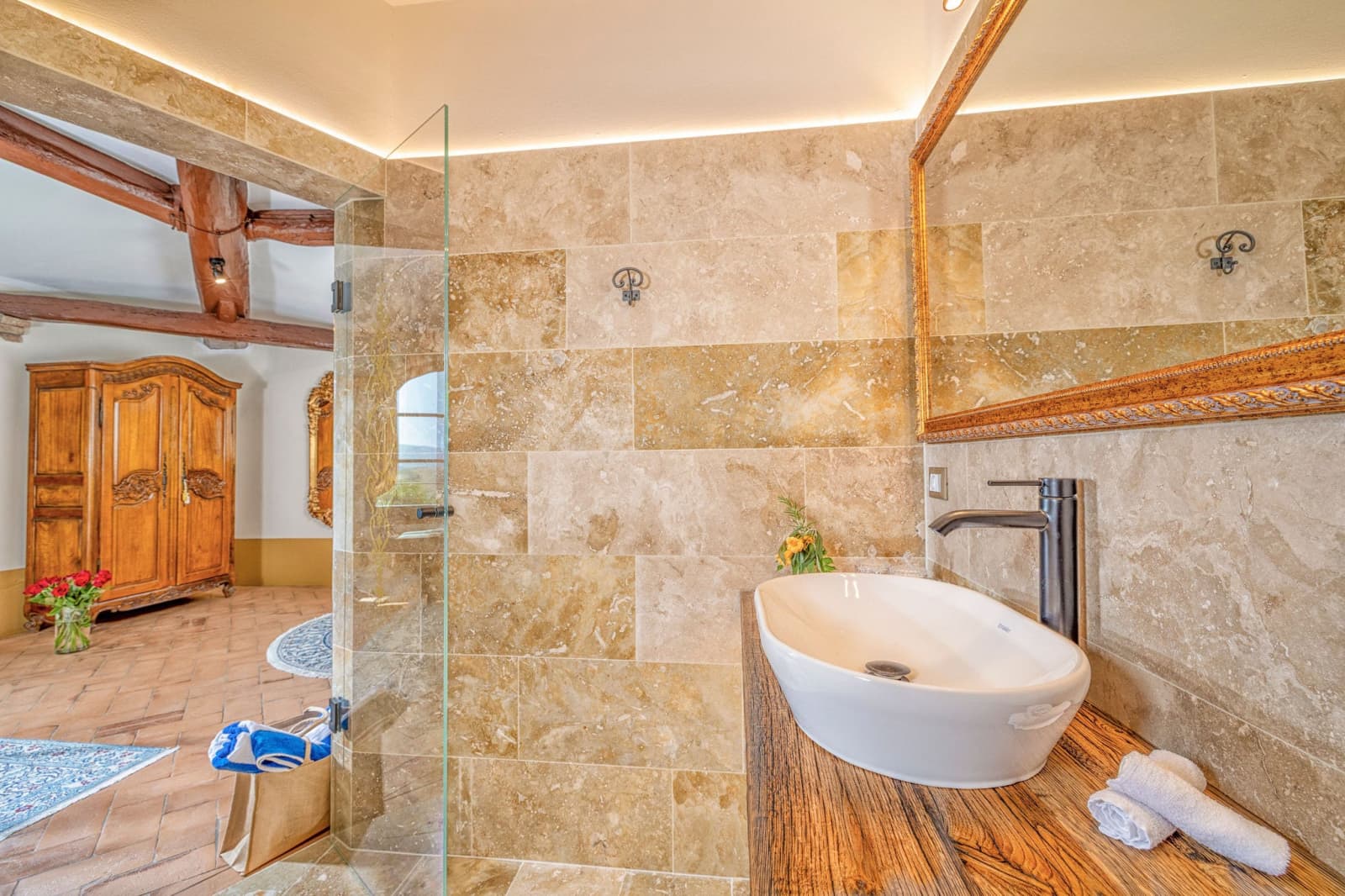 Villa Poggio d'Oro — a travertine bathroom with a glass shower