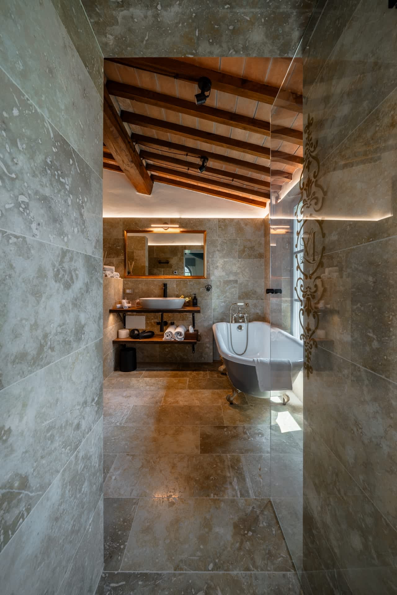 Villa Poggio d'Oro — a travertine bathroom with a freestanding tub