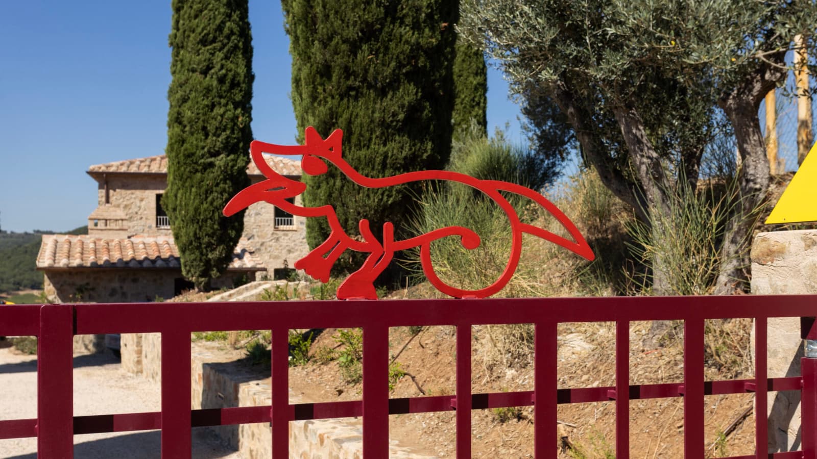 Podere Mastrojanni — the entrance gate, with the estate's fox emblem