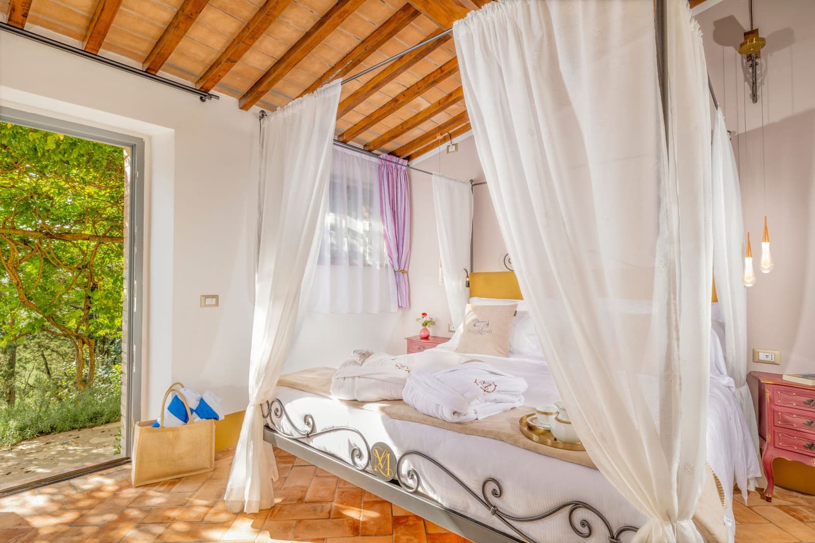Villa Poggio d'Oro — a canopy bed with doors open to the garden