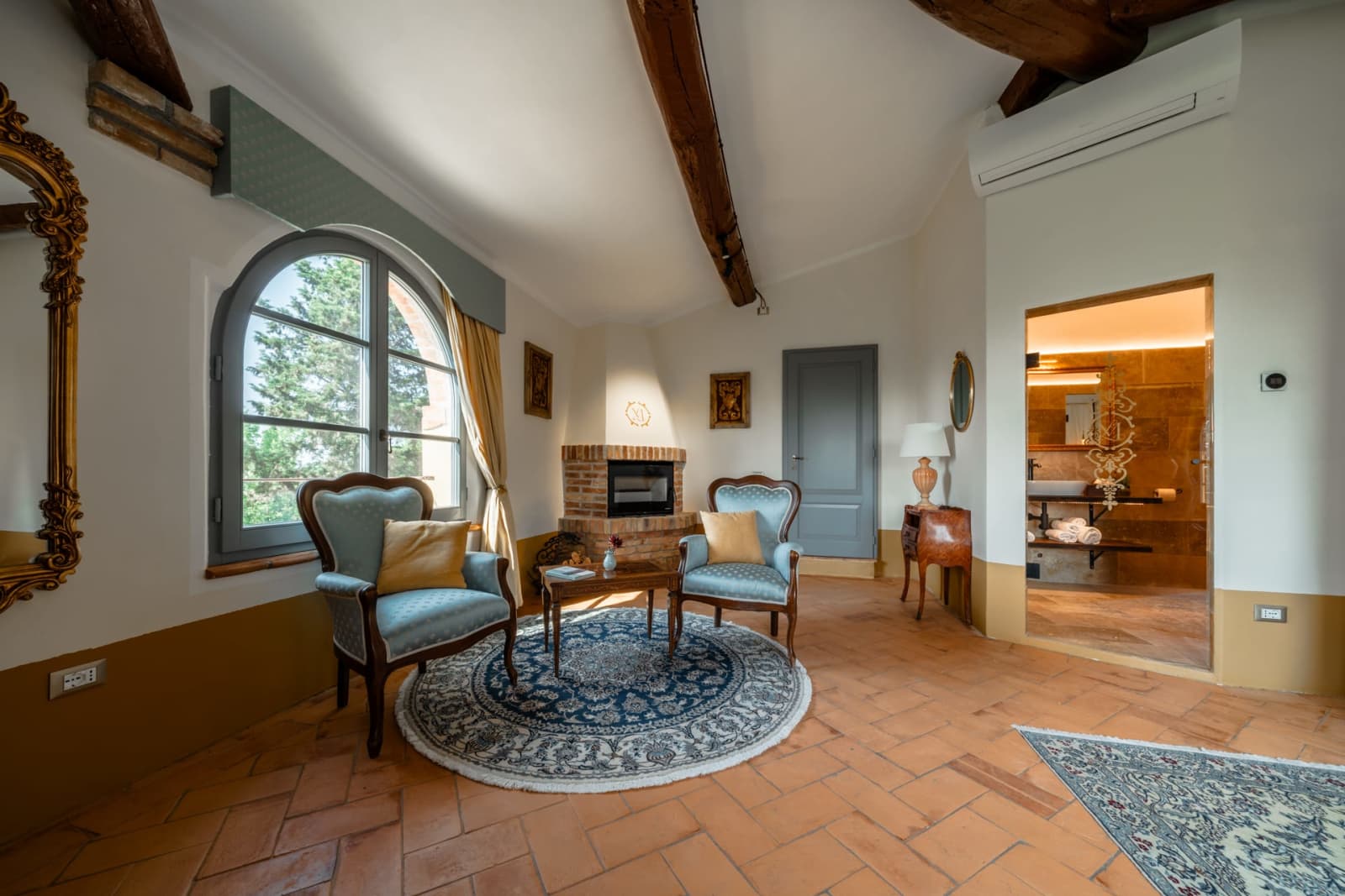 Villa Poggio d'Oro — a suite sitting area with antique armchairs