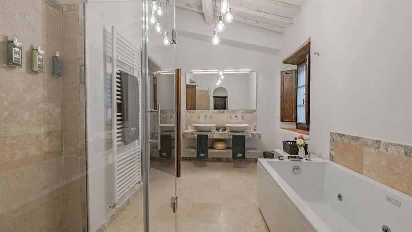 Borgo delle Vigne — a bathroom with a whirlpool bathtub, seen through the glass shower door
