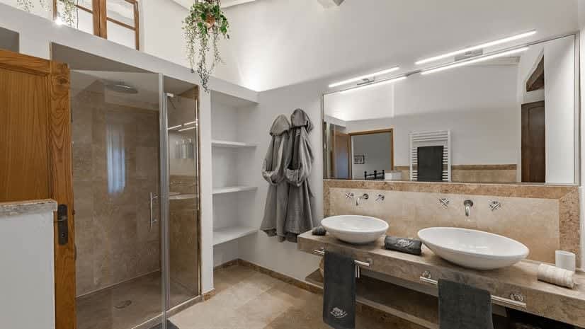 Borgo delle Vigne — a bathroom with open shelving and a double vanity, beneath a mezzanine