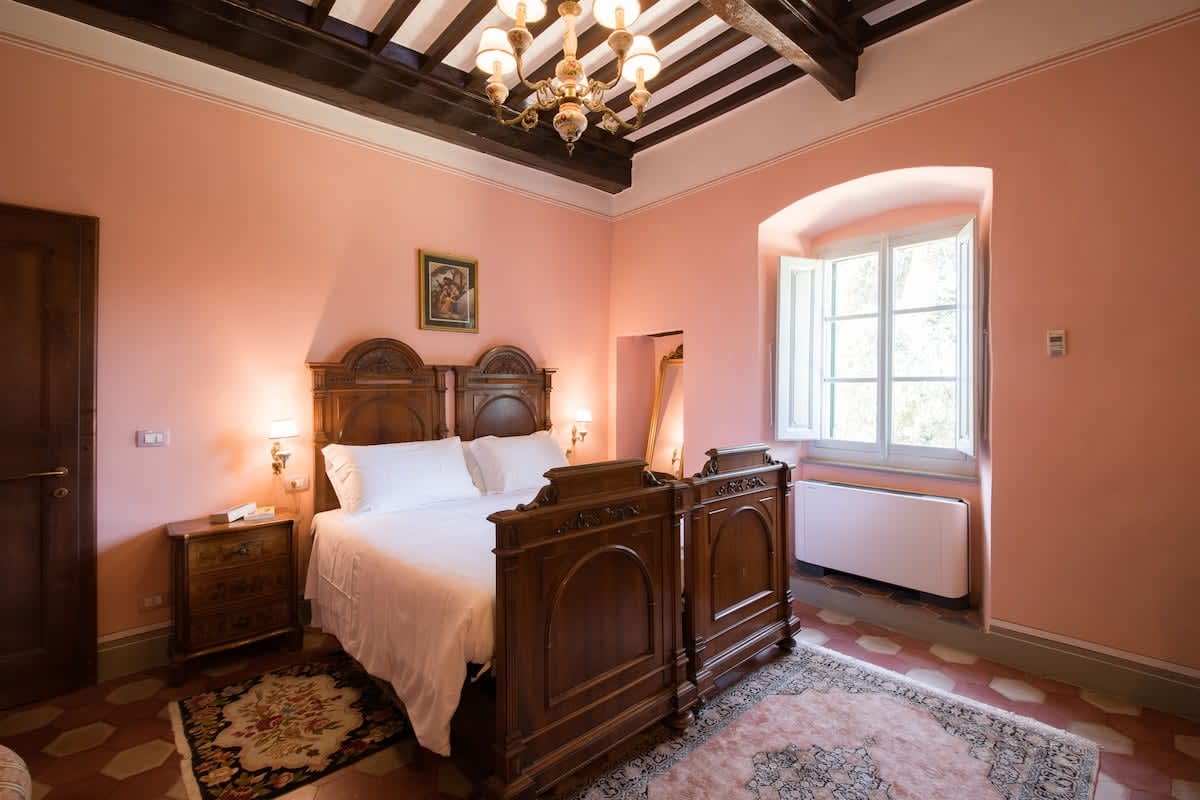 Villa della Cappella — a bedroom with a dark wood headboard