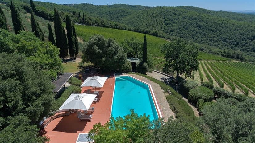 Borgo delle Vigne — an aerial view of the pool terrace, with the Chianti hills beyond