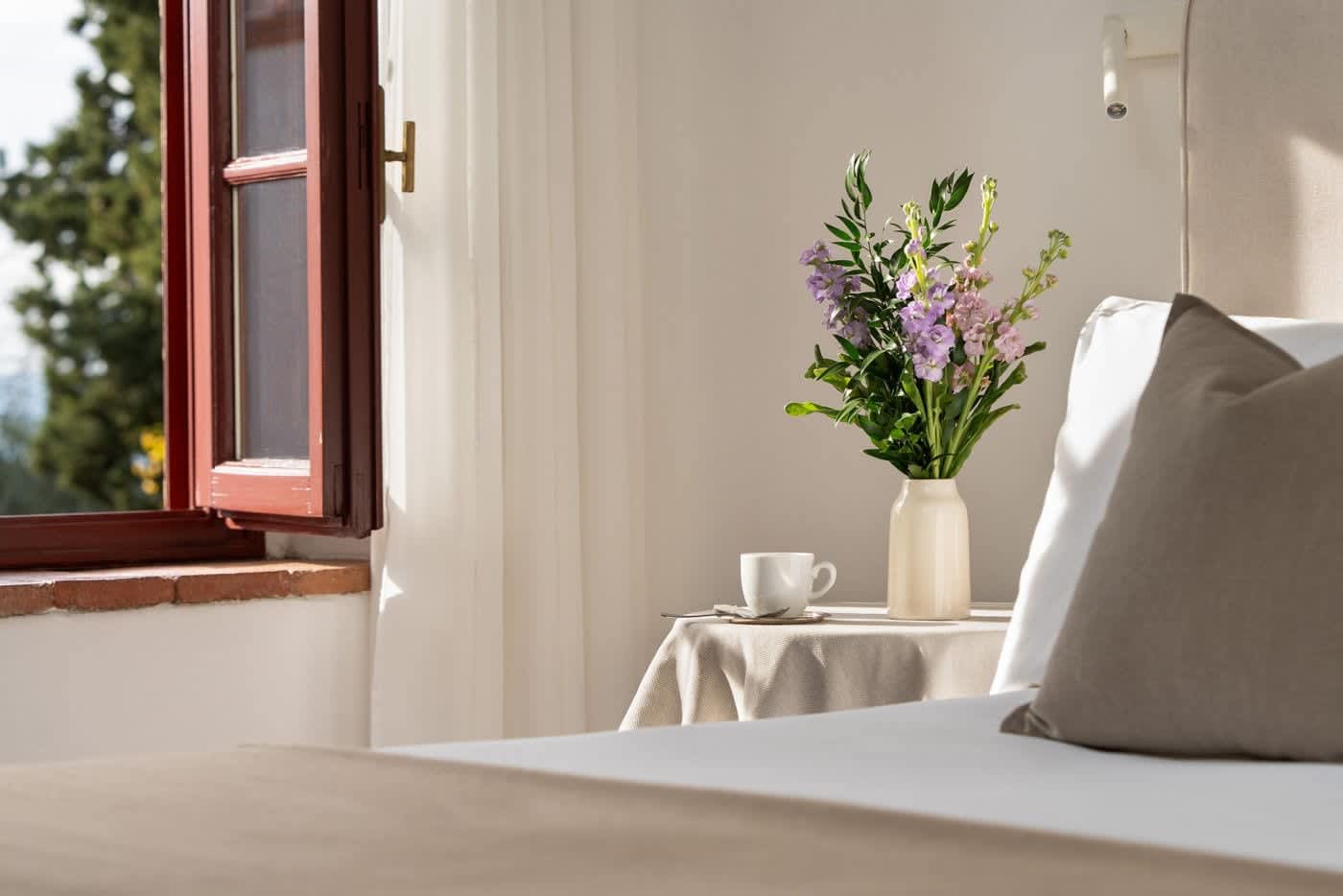 Villa Castellaro — a sunlit bedroom with fresh flowers