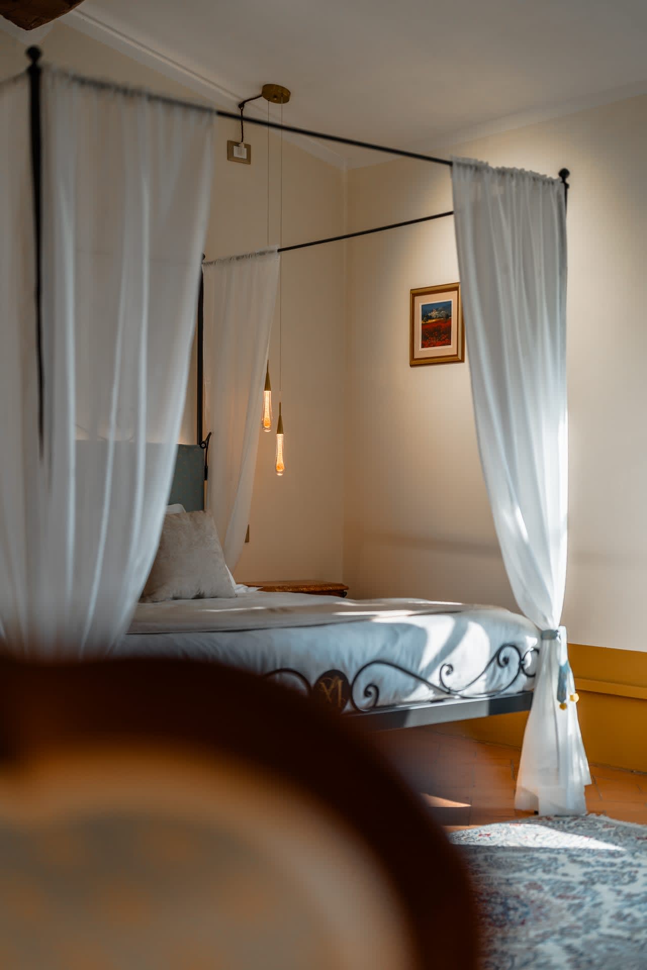 Villa Poggio d'Oro — a canopy bed beneath the beams