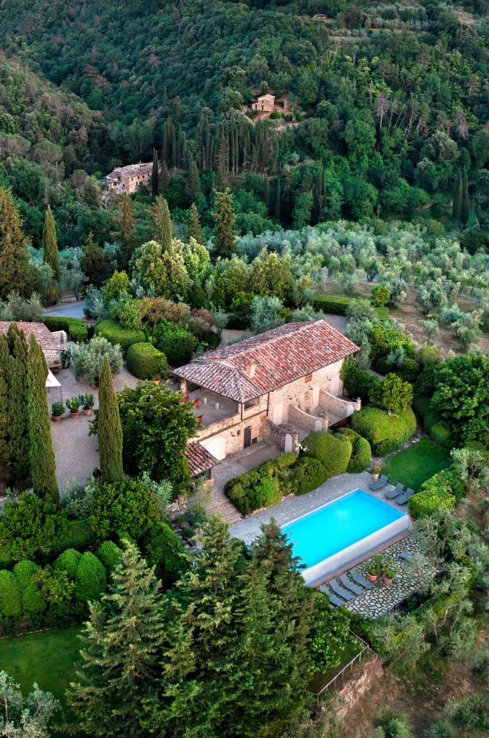 Casale Gherardi — aerial view of the stone farmhouses and pool among the olive groves
