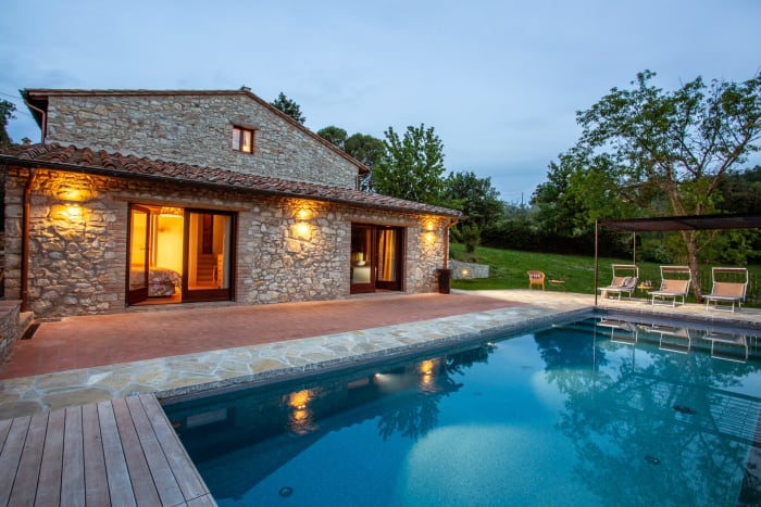 Casa Pernicella — the stone house above its infinity pool at dusk