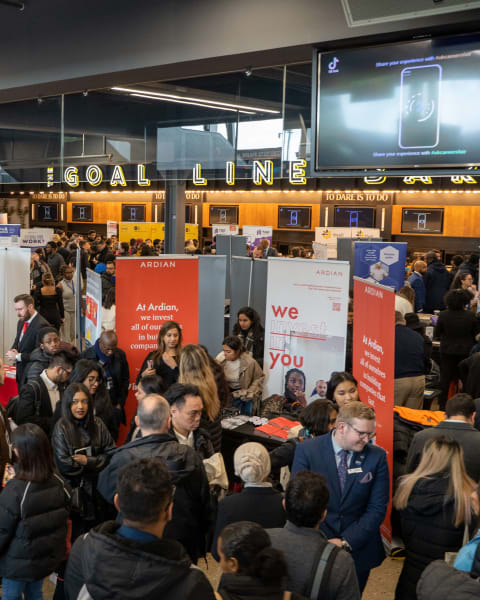 Candidates filling the aisles between exhibitor stands at a busy careers fair