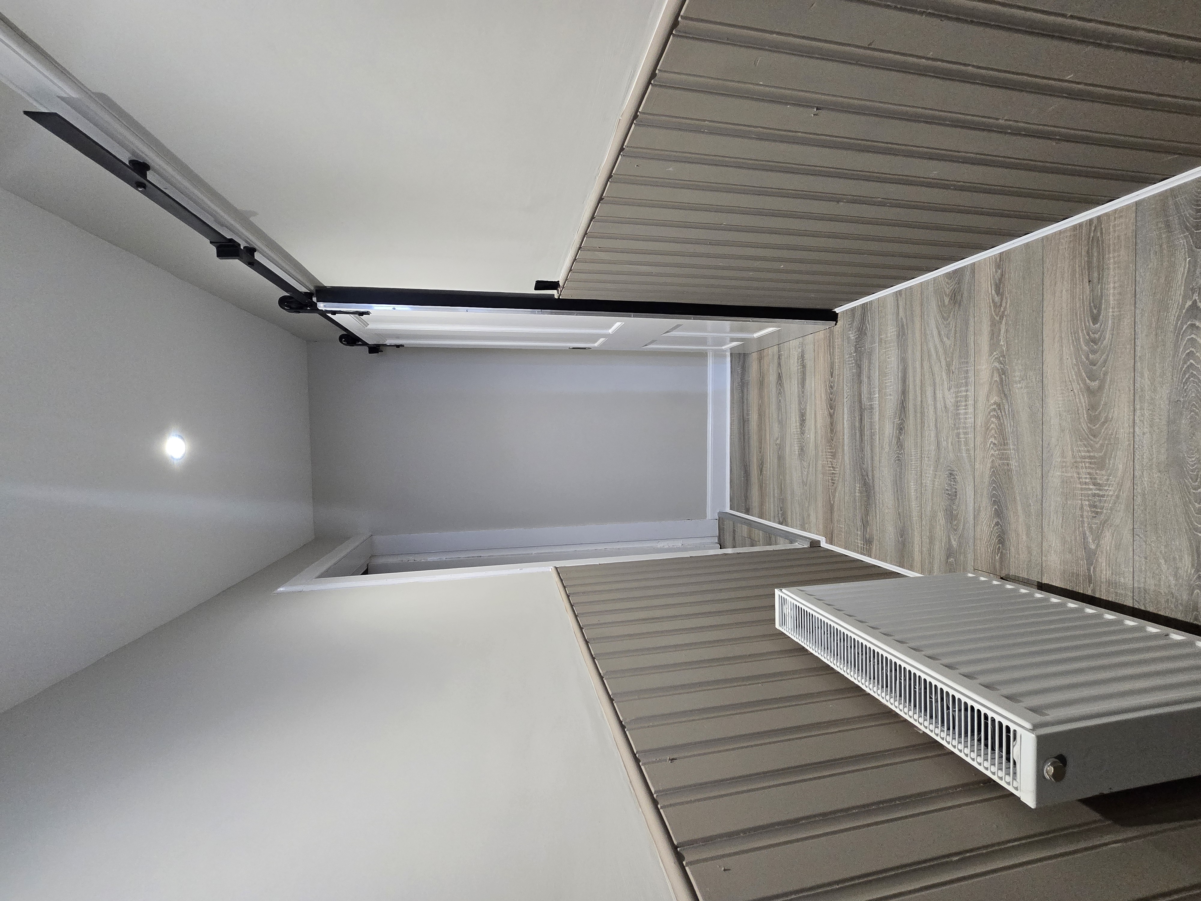 Hallway after renovation — LVT flooring, tongue and groove wainscoting and sliding barn door, property refurbishment Wishaw