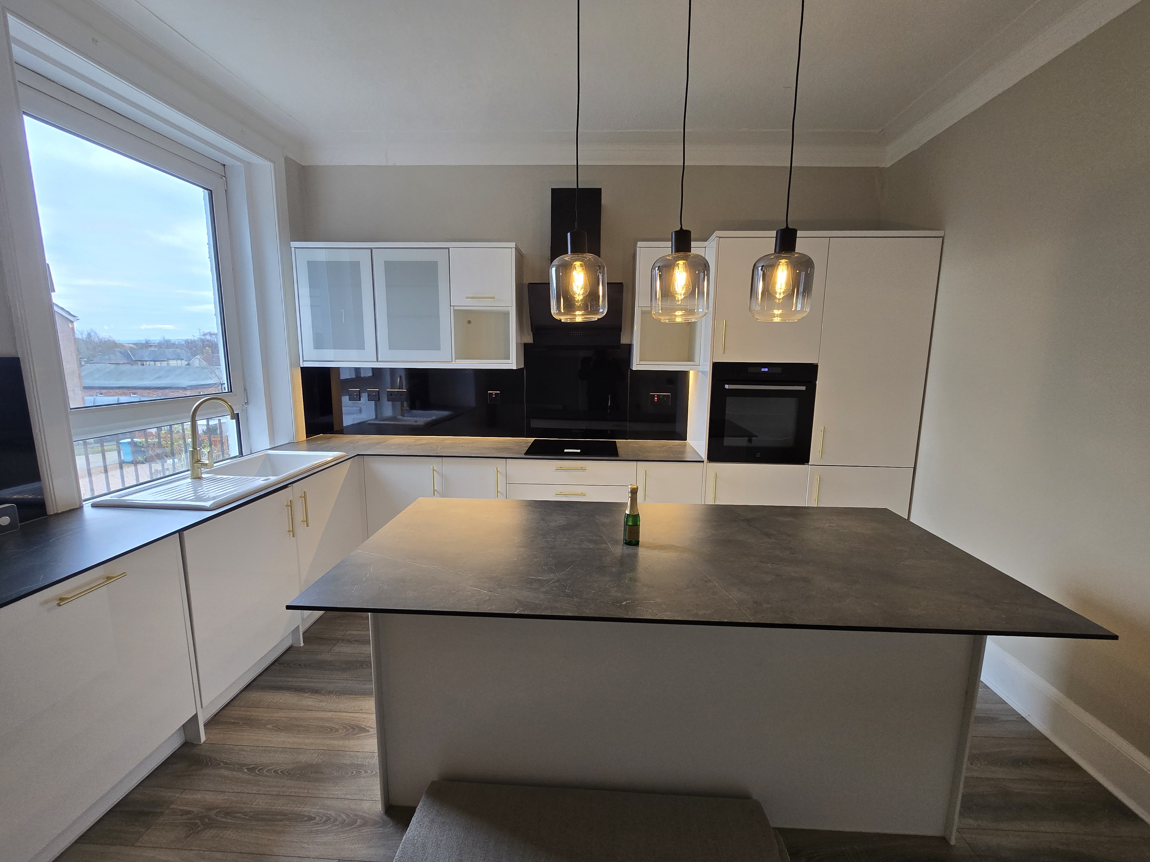 Kitchen island with dark stone worktop and brass hardware — investor refurbishment project managed by Murphy PM Glasgow
