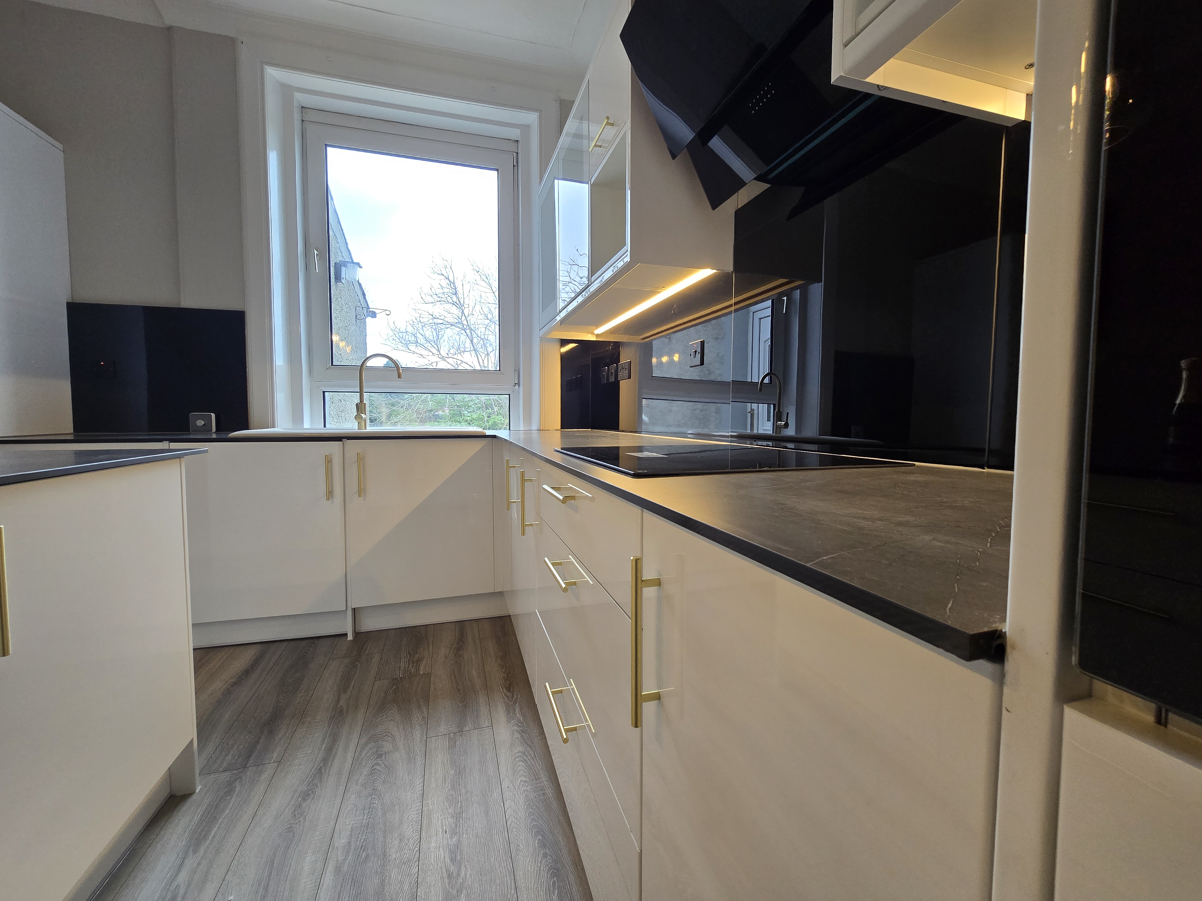 Gloss white kitchen cabinets with brass handles — high specification property refurbishment, North Lanarkshire