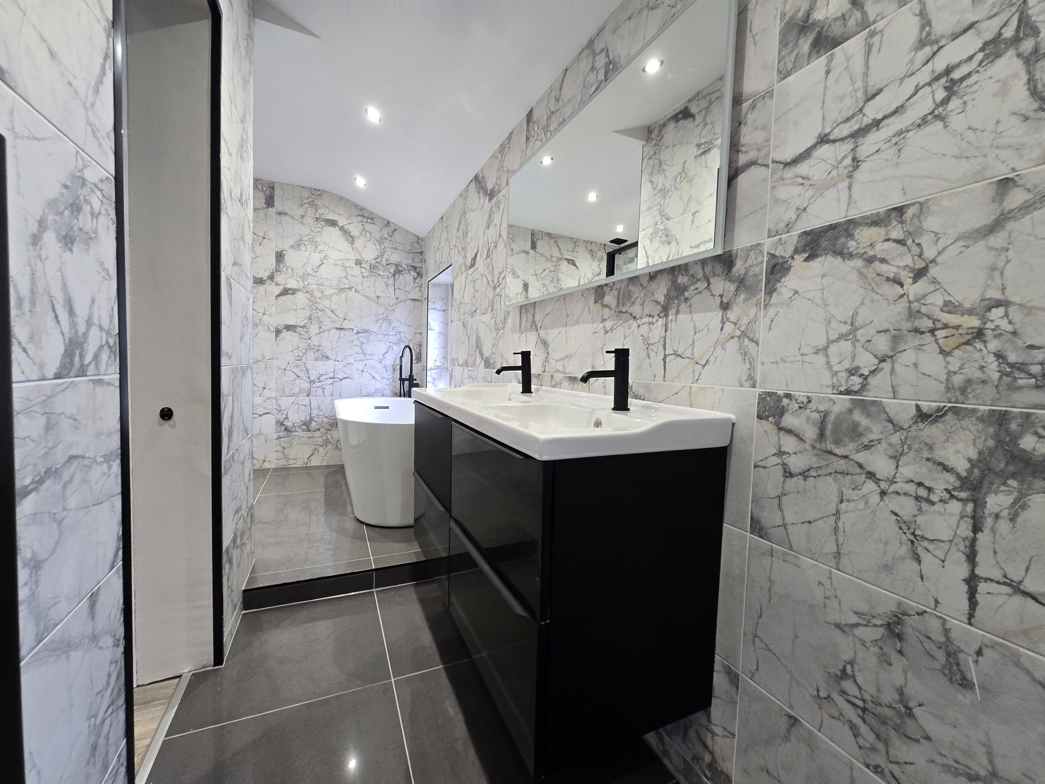 Full length bathroom with floor-to-ceiling marble effect tiles — luxury investor refurbishment managed by Murphy PM Glasgow