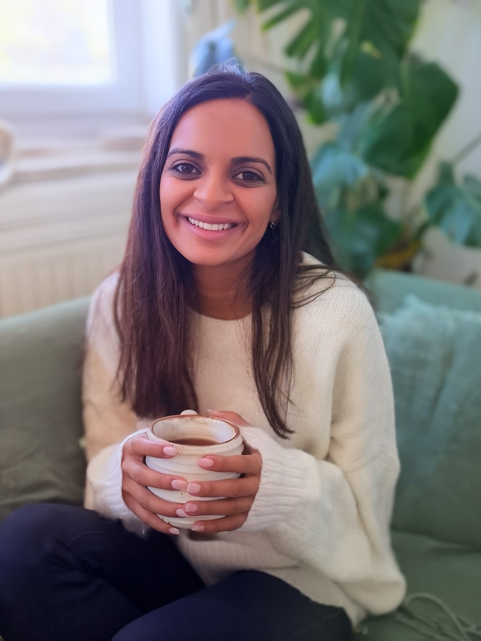 Dr. Dibah Jiva on a couch with tea