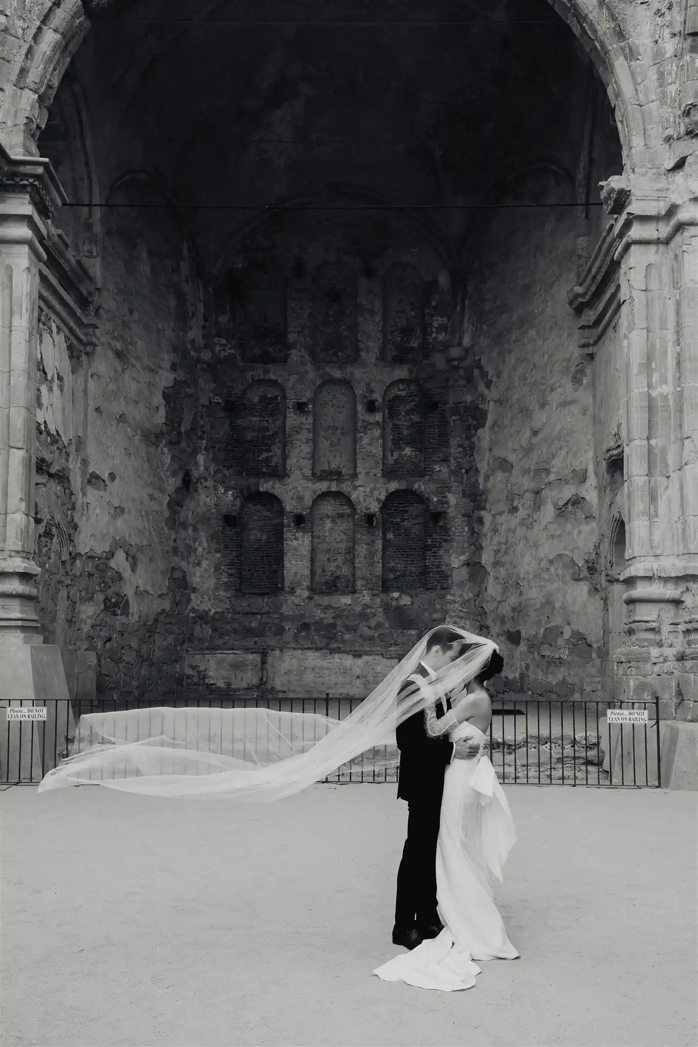 bride and groom kissing under the veil at the old mission after wedding ceremony capturing candid love and marriage of the newlywed