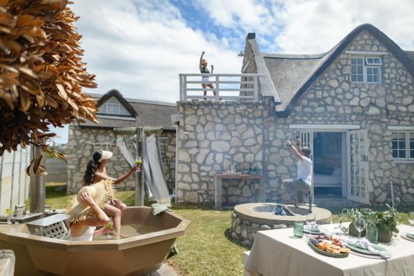Kob Cottage, a stone and thatch home with wood-fired hot tubs in Struisbaai