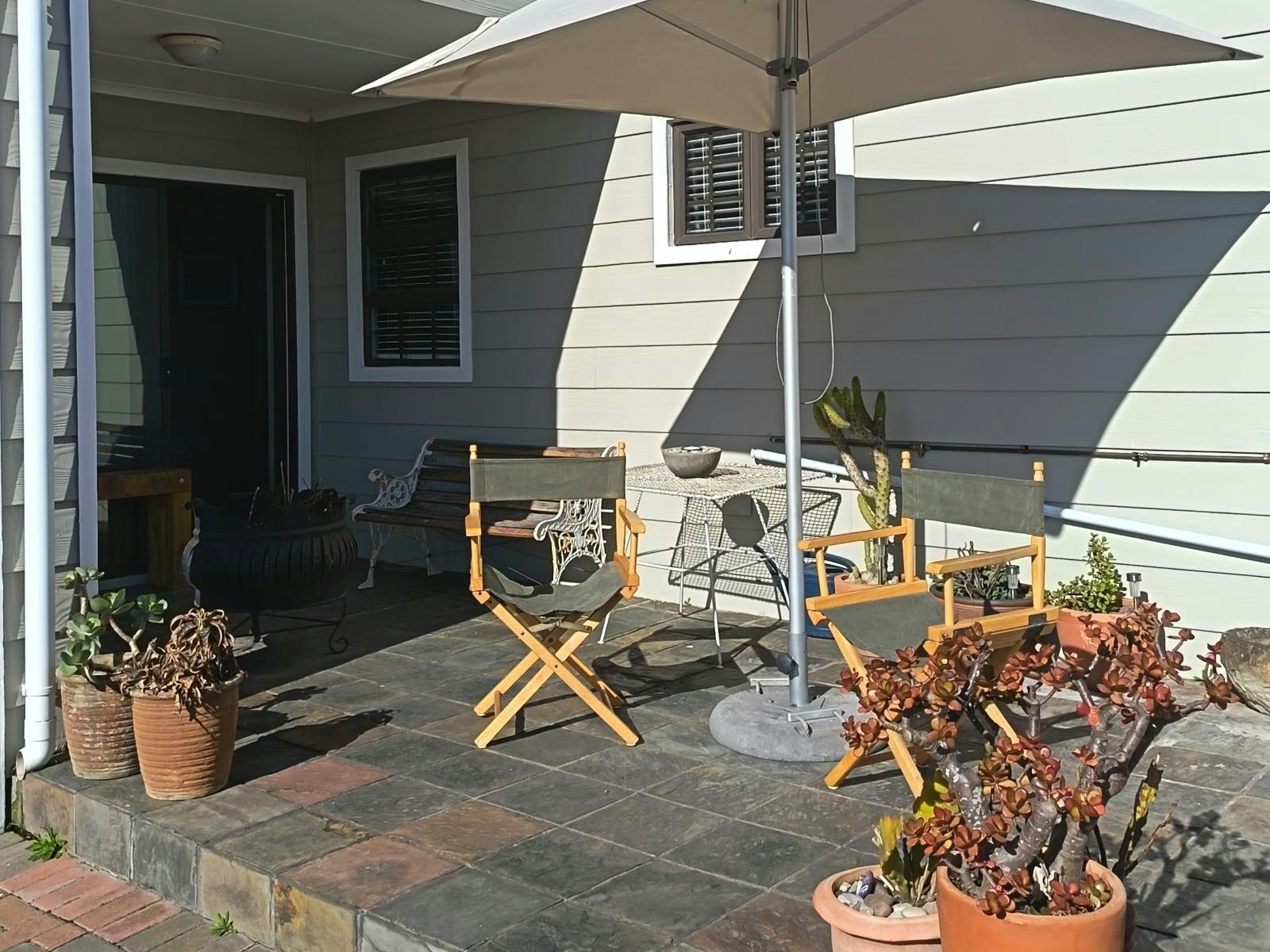 Sheltered patio with umbrella and director chairs